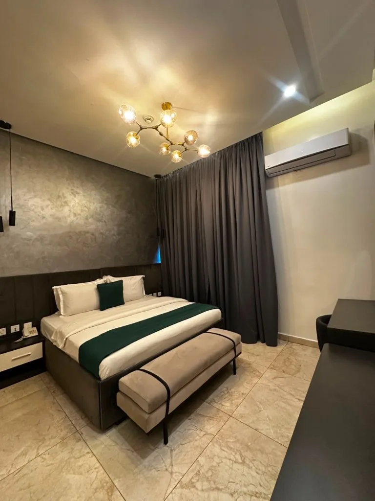 Deluxe Room with teal accents and a gold chandelier