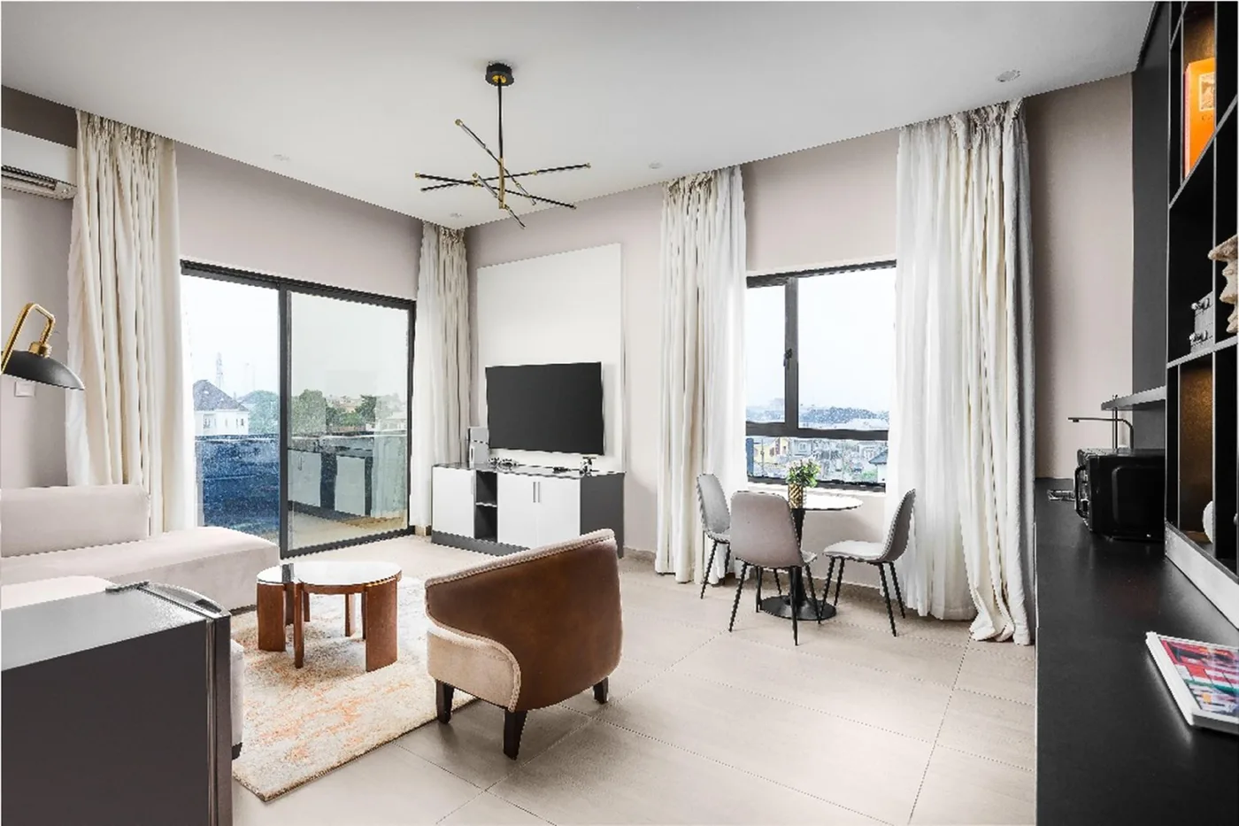 Suite living area with sofa, dining table and balcony light